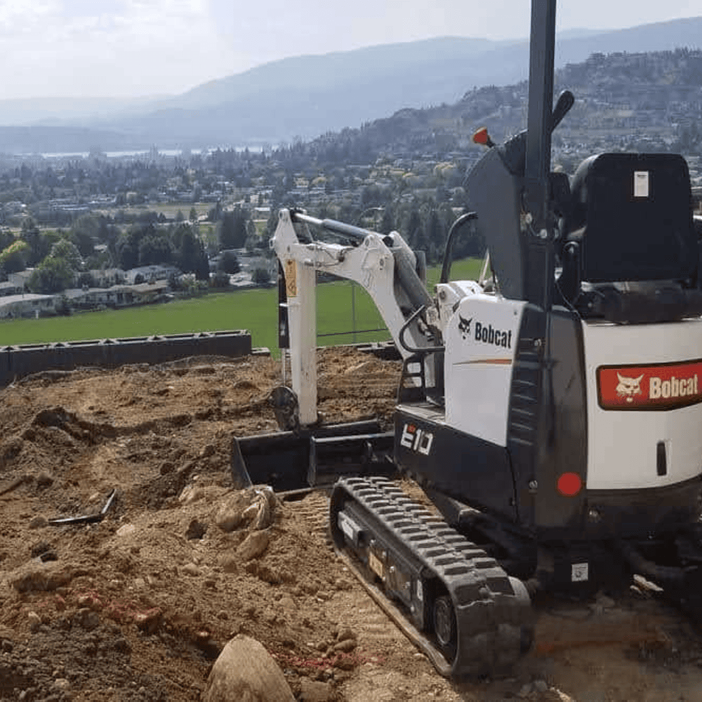excavator grading a backyard